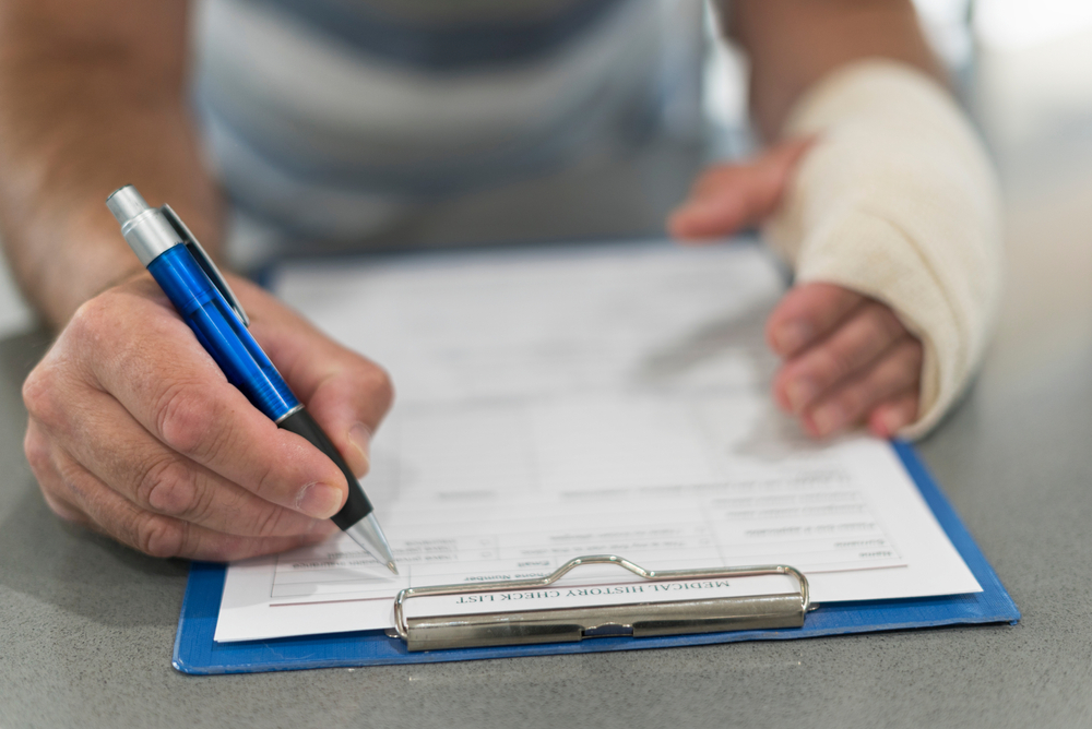 a person filling in medical forms after an injury