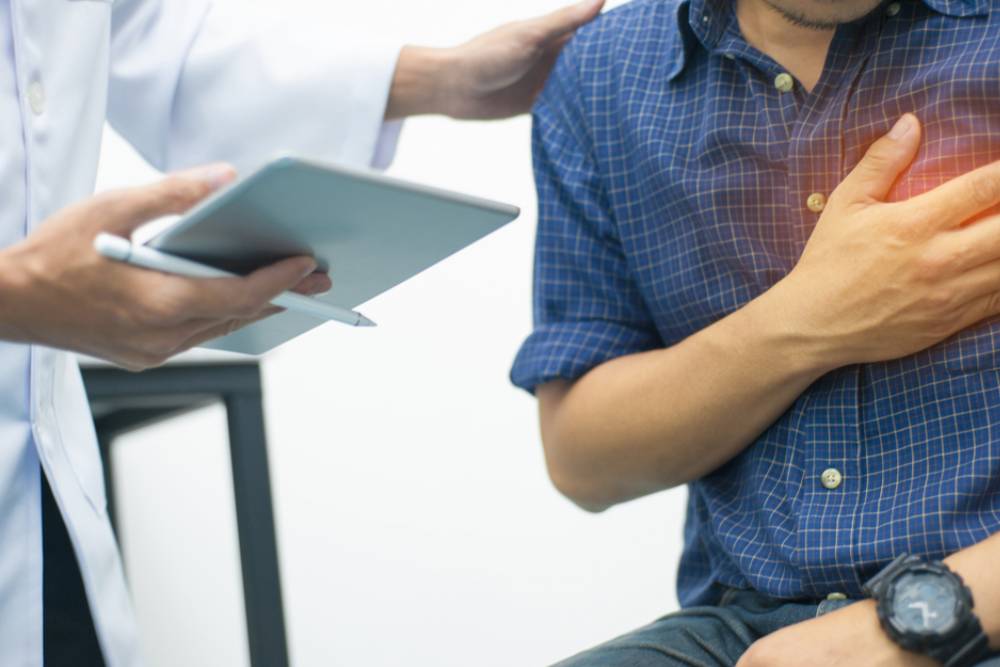 The doctor is diagnosing the pain in the chest area of the patient