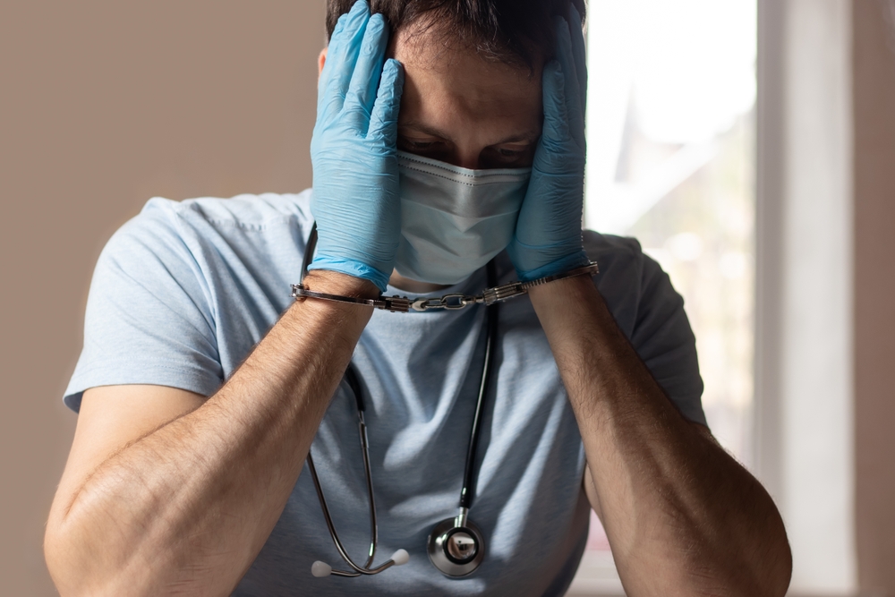 The handcuffed doctor. Concept on the topic of medical negligence.