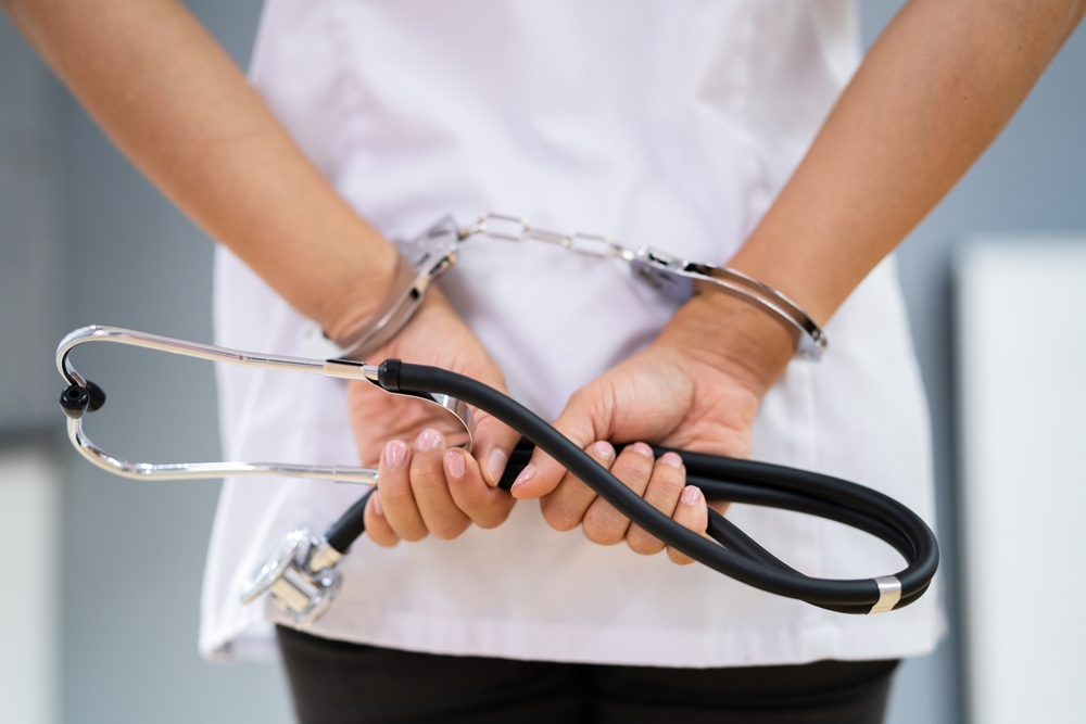Medical Malpractice And Medicine Fraud. Healthcare Physician In Handcuffs