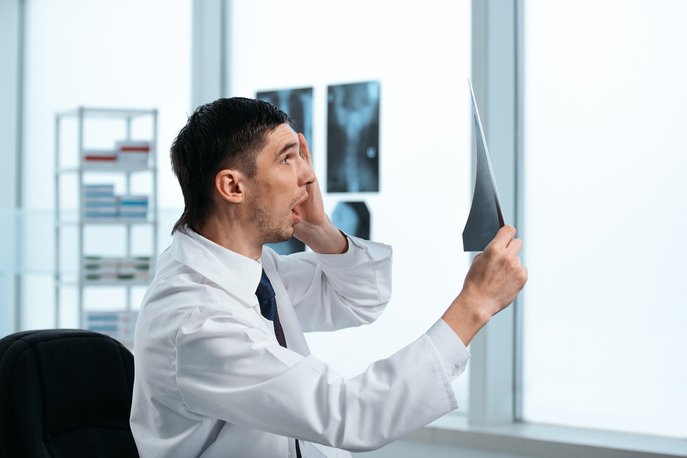 surprised doctor looking at the patient's X-ray.