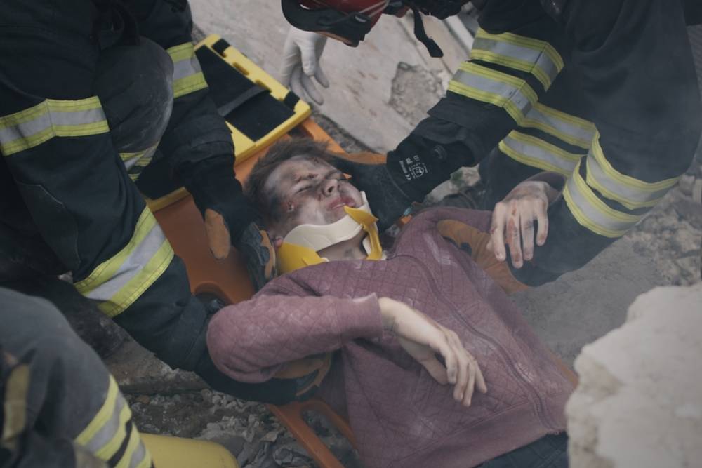 Emergency service workers pulling survivor from rubble